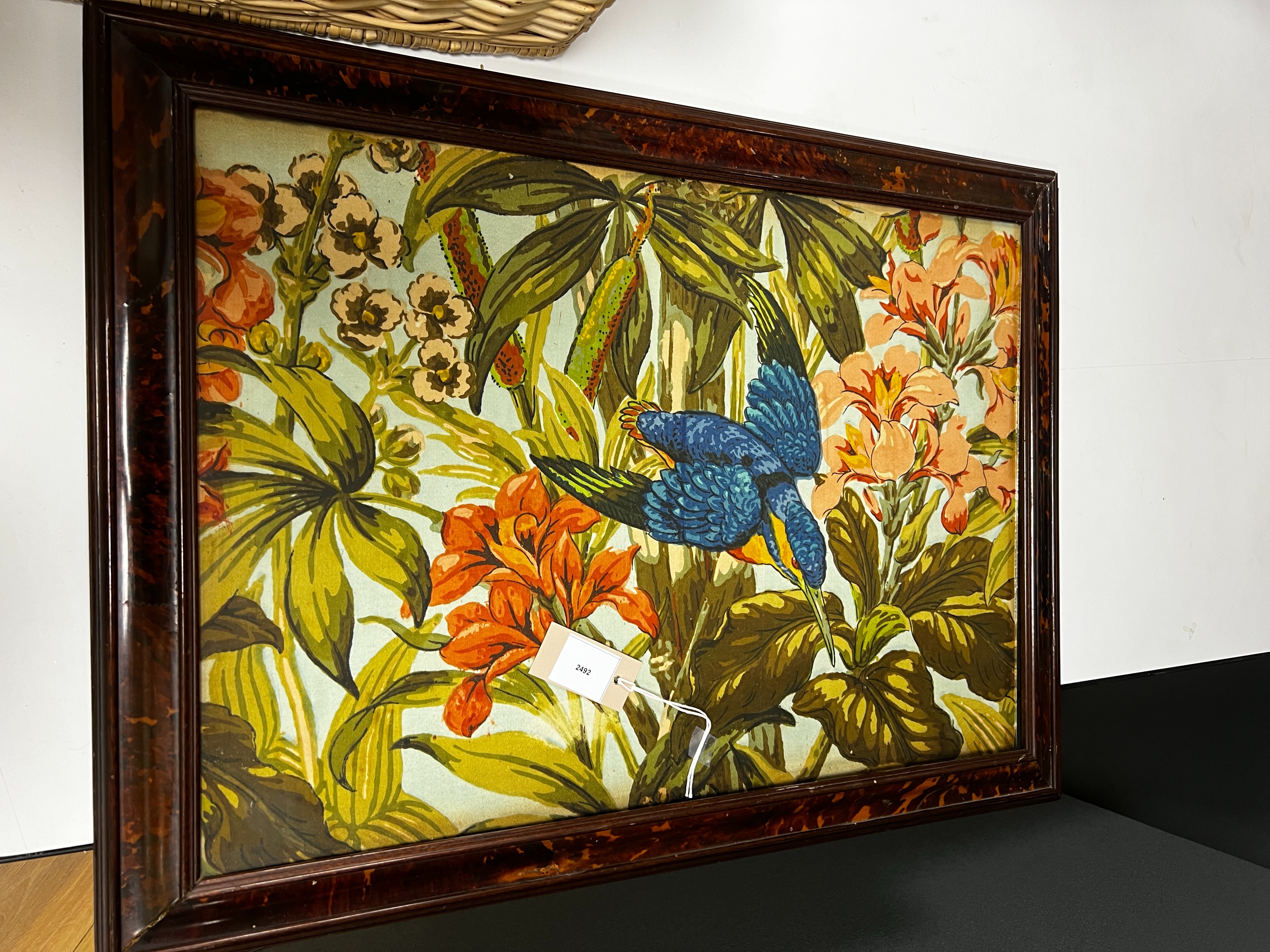 A large rare tortoiseshell picture frame and exotic panel of printed fabric, 70 cms wide x 52 cms high including frame